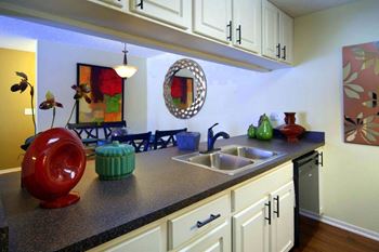 Kitchen with White Cabinets and Black Counter Tops at Coral Club, Bradenton, Florida
